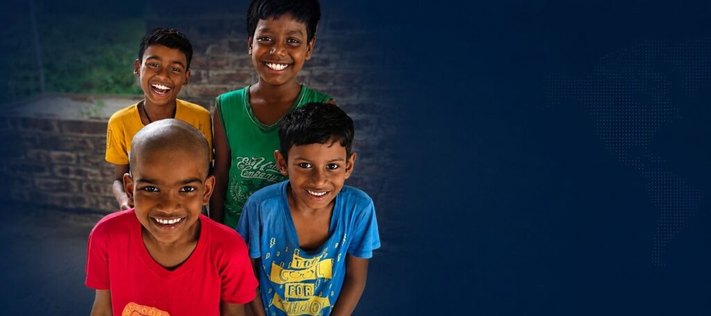 Smiling children supported through New Life Fellowship Society's education and community development programs in West Bengal, India.